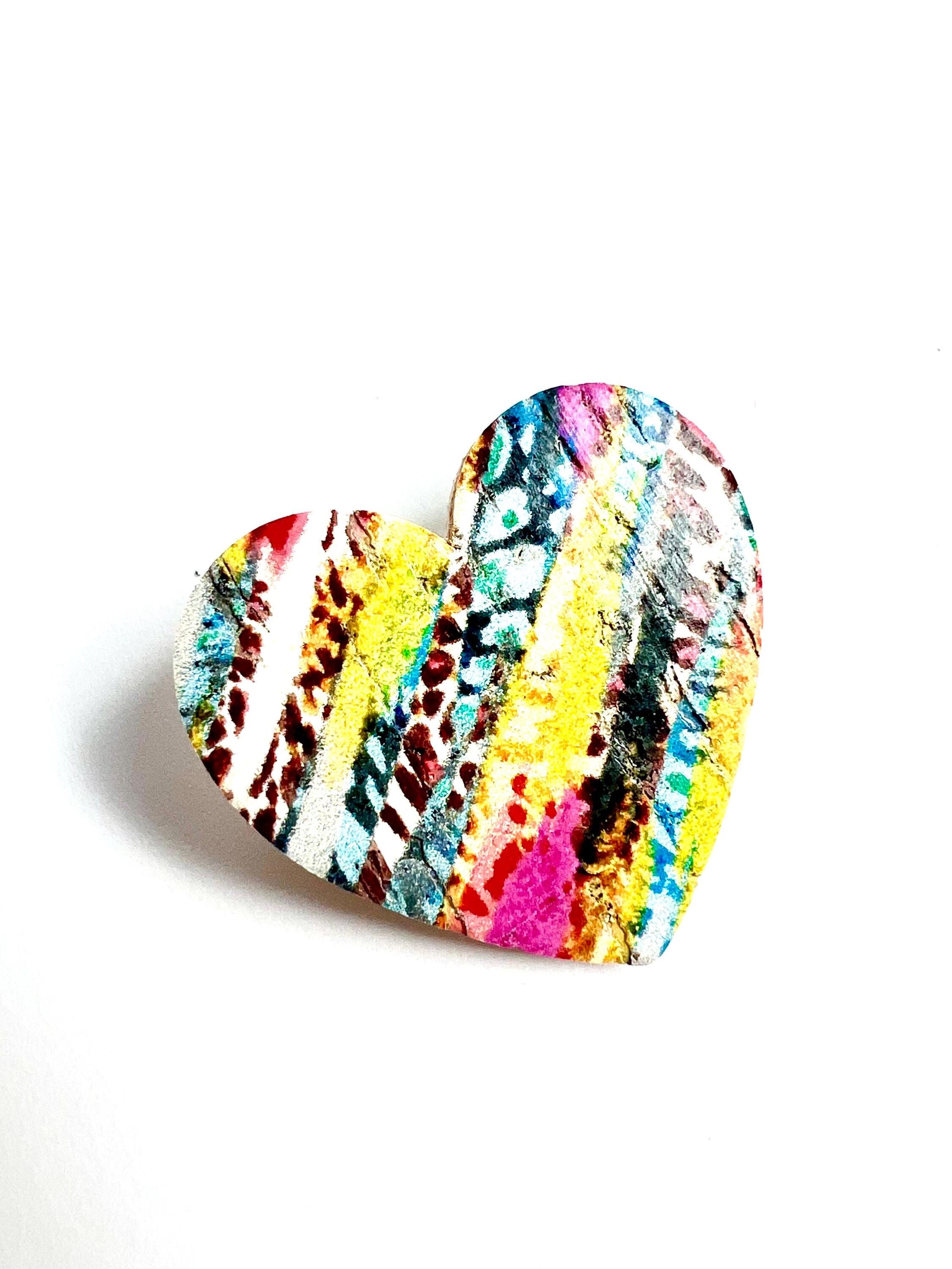 Broche en forma de corazón de corcho y cuero con un colorido diseño abstracto.
