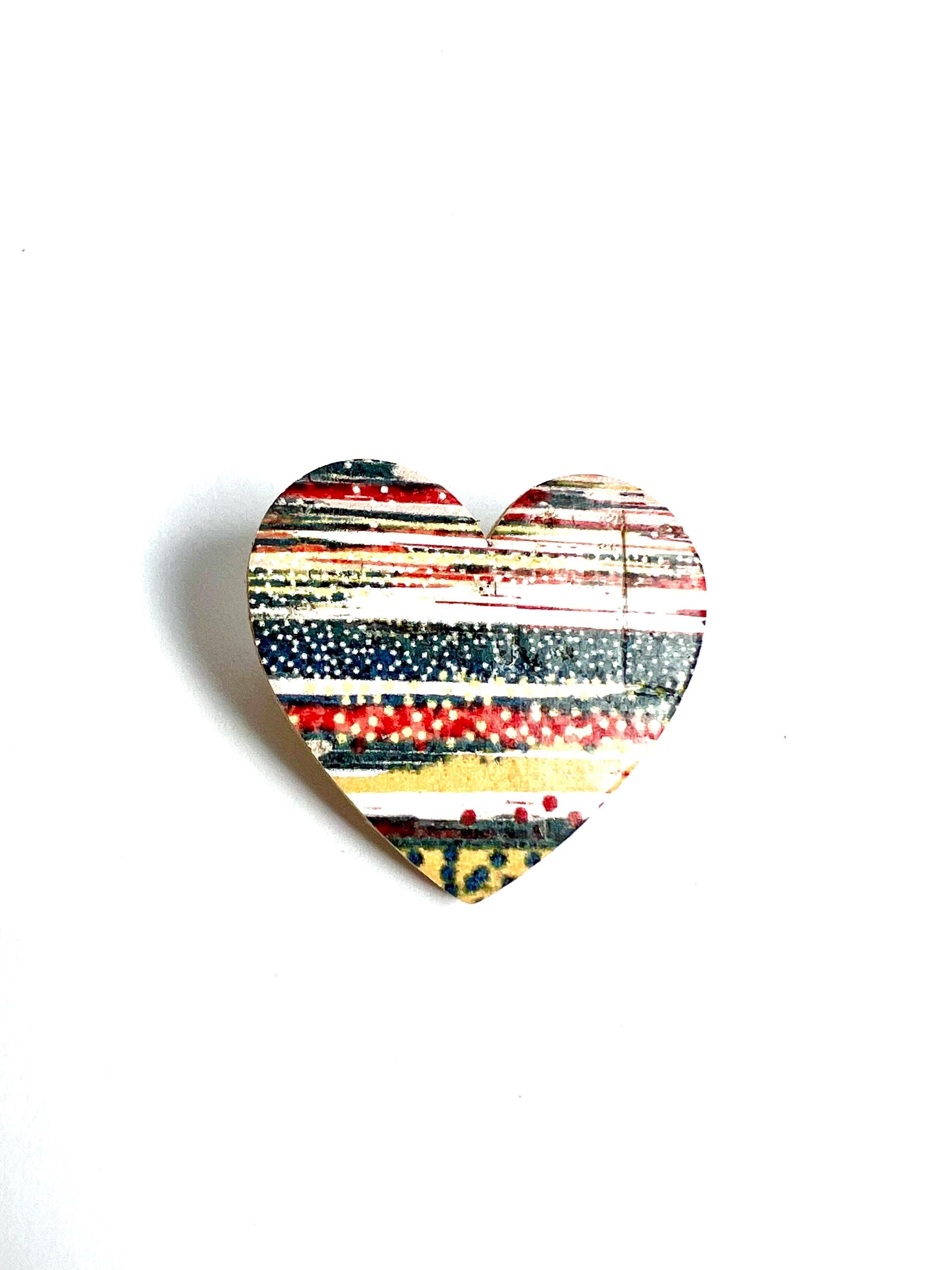 Broche en forma de corazón de corcho y cuero con estampado de rayas multicolores.