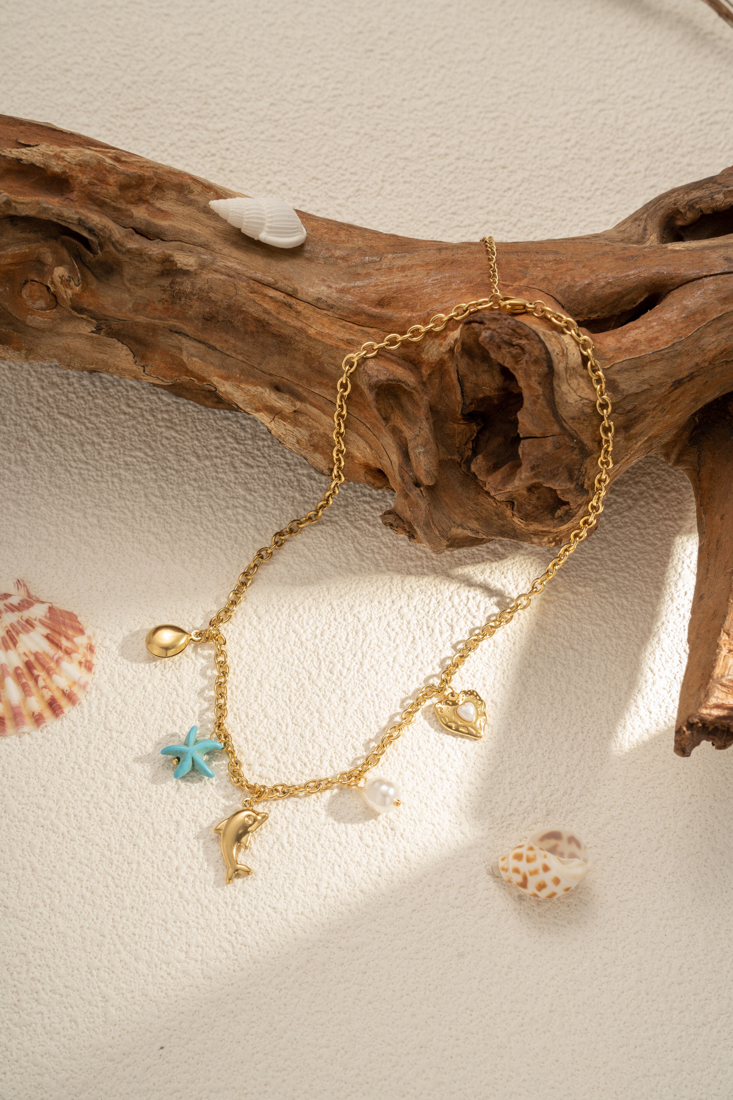 Gold-tone necklace with nautical charms, turquoise star, dolphin, pearl, heart, and stainless steel – chic