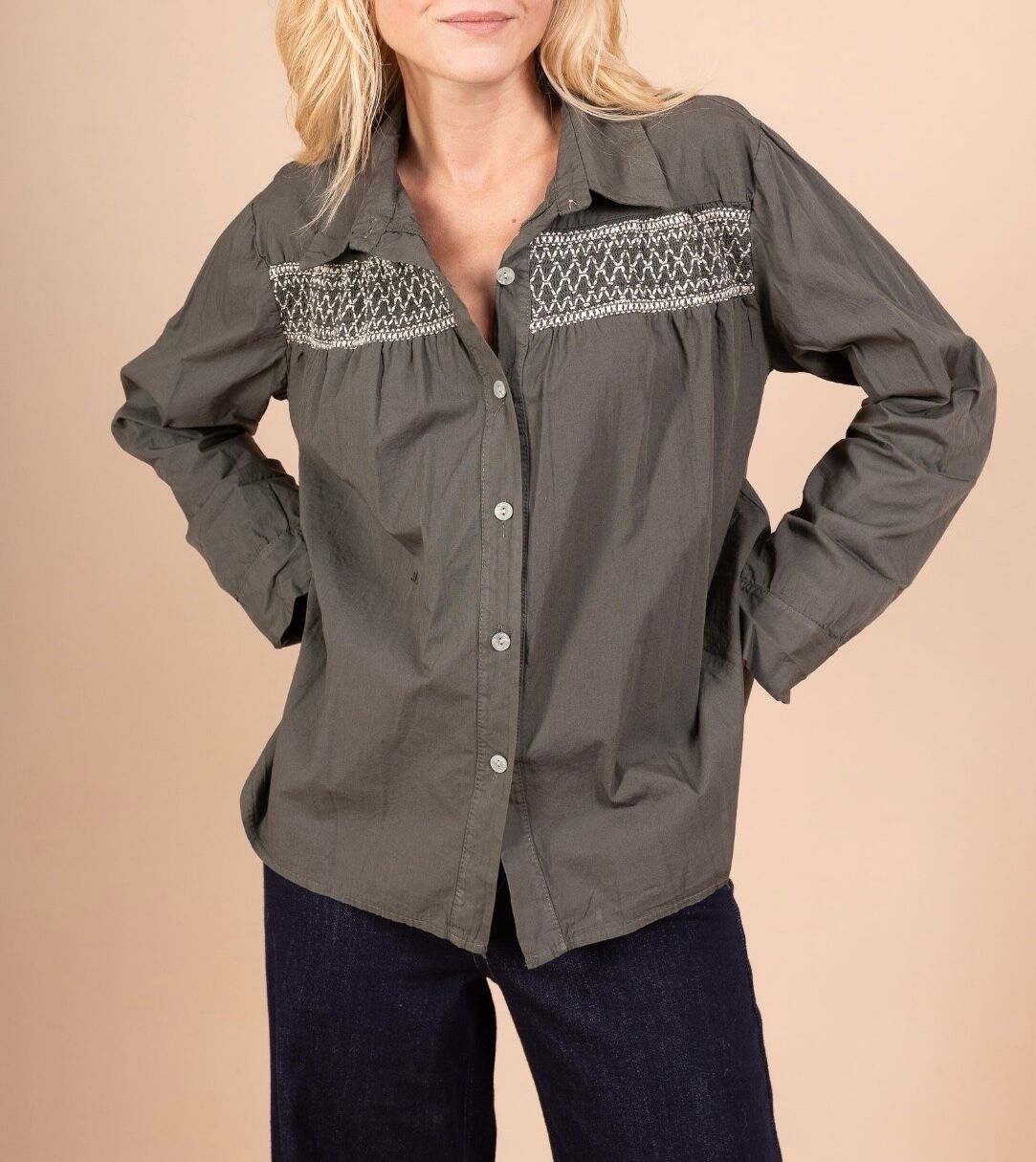 Bohemian long-sleeved shirt with buttoned cuffs; the bib is highlighted by a wide band of smocking embroidered with gold thread.