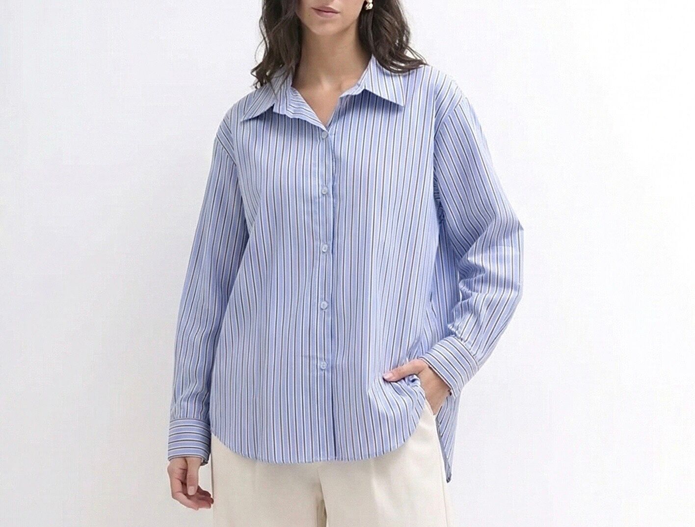 Loose-fitting, long-sleeved shirt with buttoned cuffs and two-tone vertical stripes.