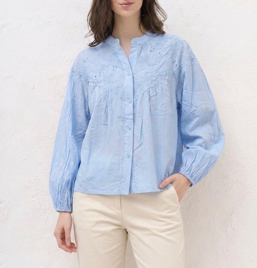 Long-sleeved shirt with elasticated cuffs, Mao collar, and a bib adorned with floral embroidery and subtle openwork details.