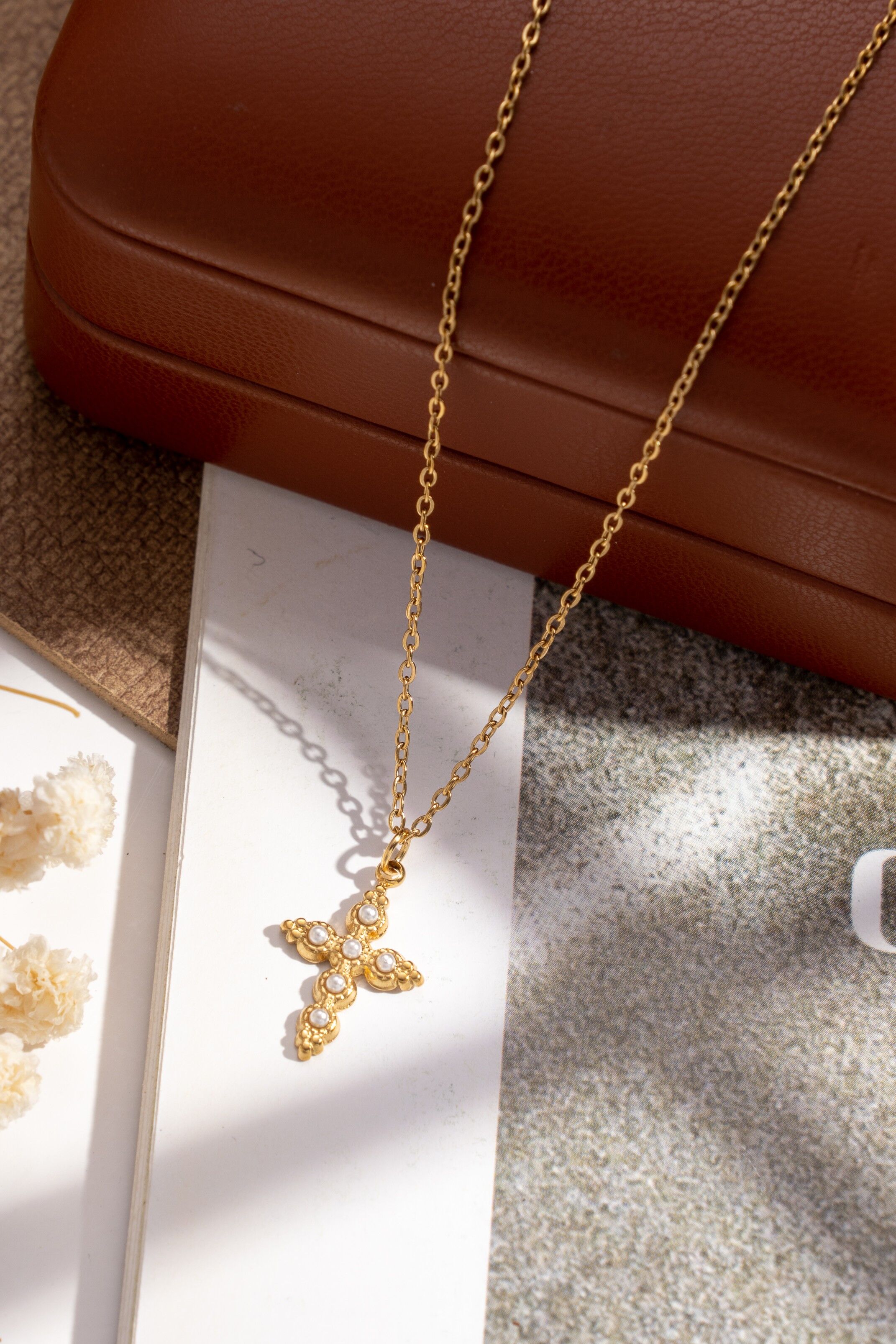 Gold cross necklace adorned with crystals and stainless steel beads