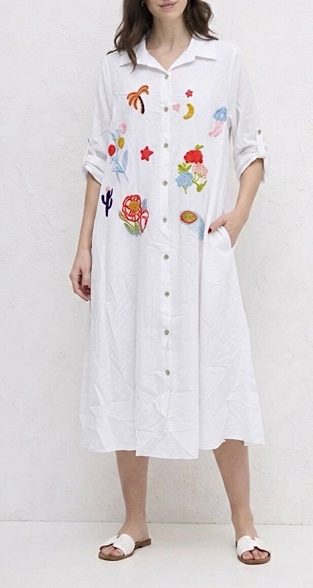Long bohemian shirt dress with long sleeves featuring internal button tabs allowing them to be rolled up into 3/4 sleeves, 2 side pockets, multicolored embroidered motifs scattered across the bust