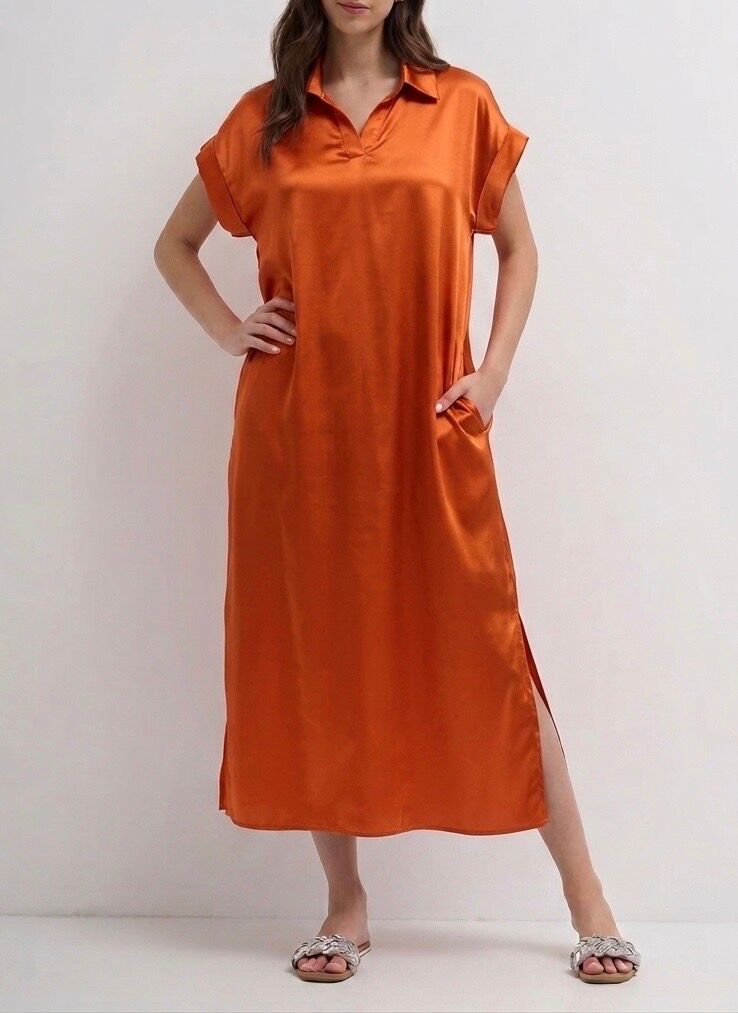 Long satin silk dress with short sleeves finished in turn-backs, shirt collar, 2 side pockets, and side slits.