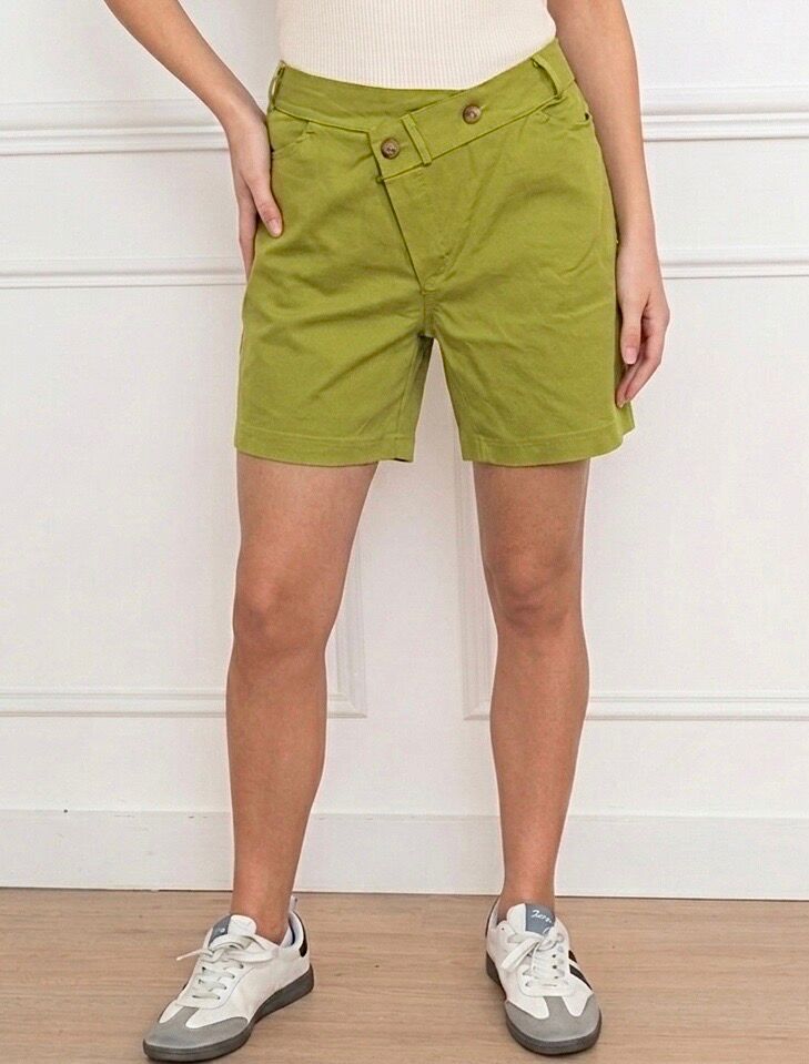 Short extensible, 2 poches latérales, taille élastique dos, taille avant asymétrique croisée maintenue 2 boutons zip en dessous