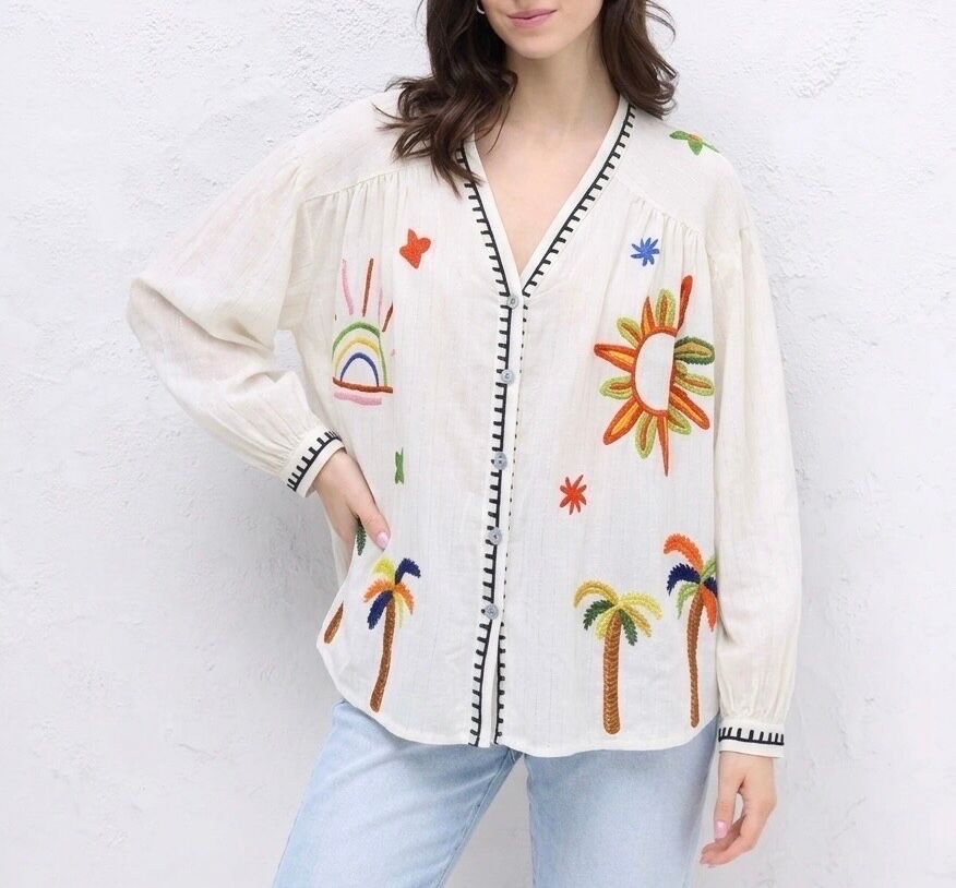 Loose-fitting bohemian shirt with long sleeves, buttoned cuffs, V-neck, silver trim throughout, and a colorful summer print on the front and back.