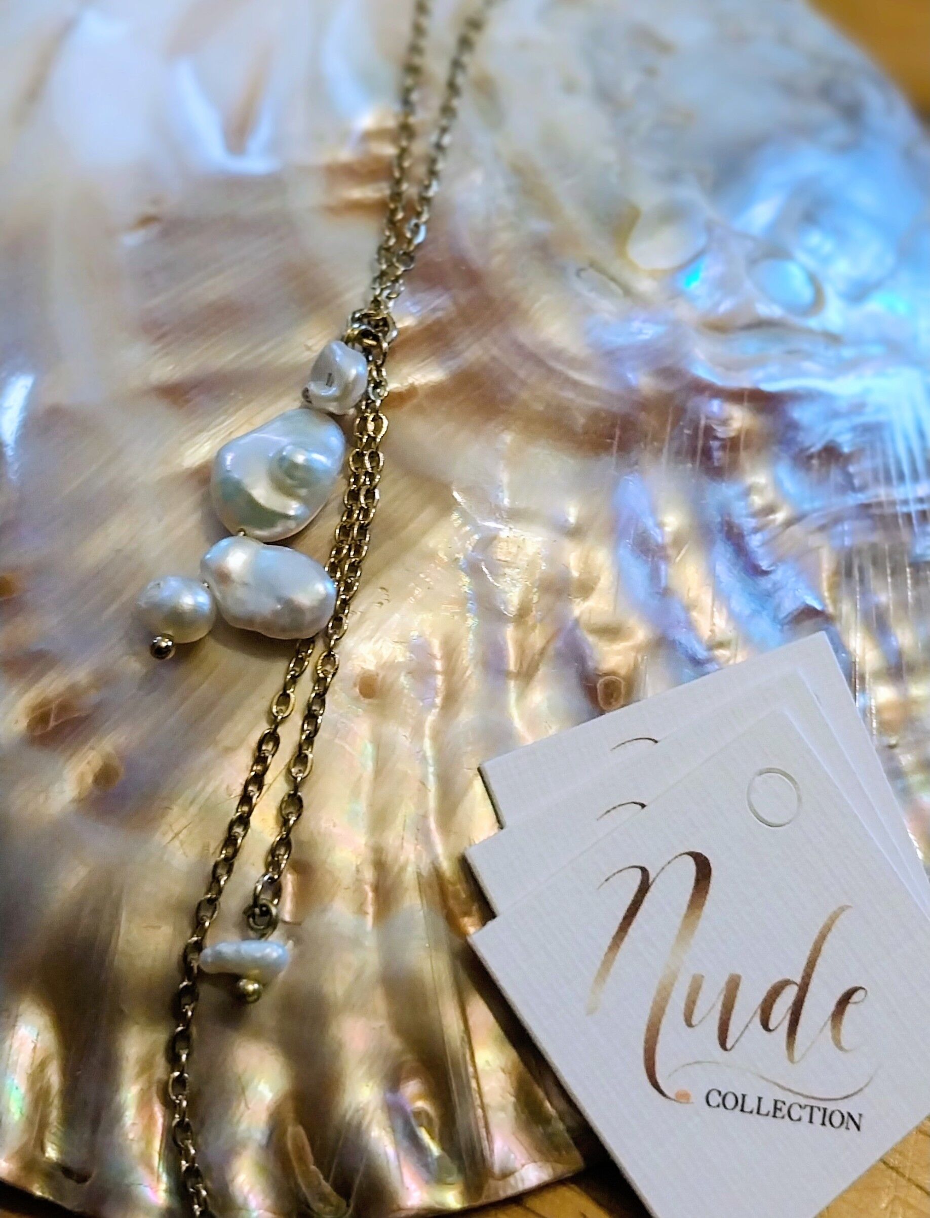 Mid-length steel necklace (50 cm) with graduated natural mother-of-pearl beads.