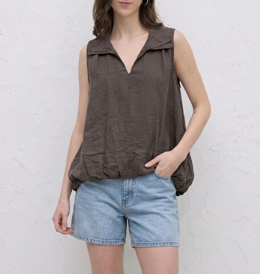 Asymmetrical sleeveless, lined top with a longer hem at the back featuring a gathered and ruffled effect and a shirt collar.