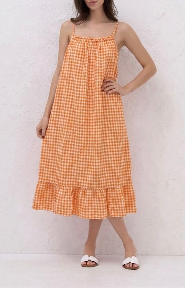 Maxi dress with thin straps, straight gathered neckline, and a wide flounce at the hem in a large gingham check pattern.