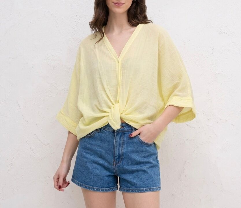 Loose-fitting shirt with dropped shoulders, kimono style, V-neck, and tie-waist effect