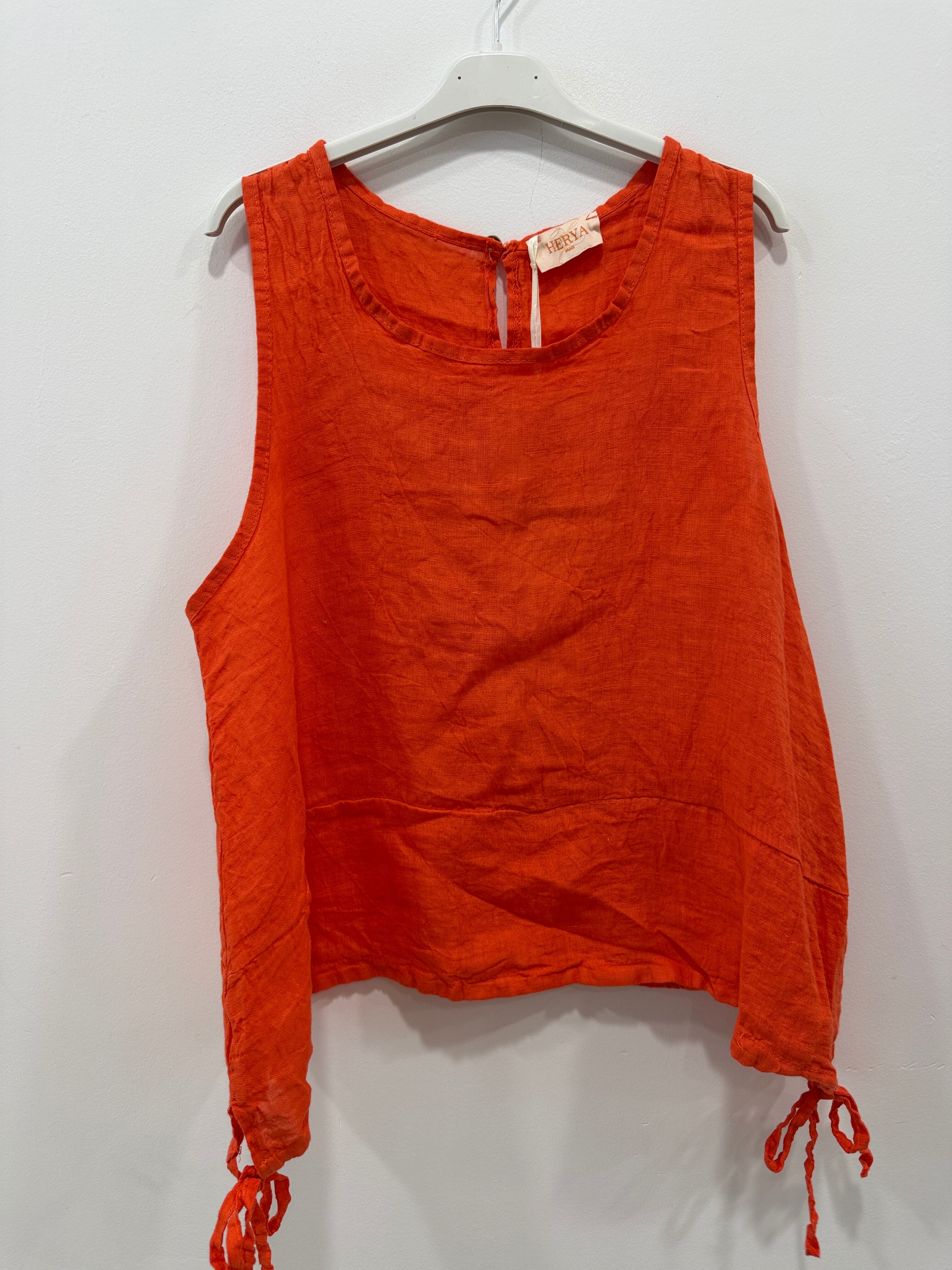 Sleeveless linen top with a round neck, buttoned slit at the back, and ties on each side.