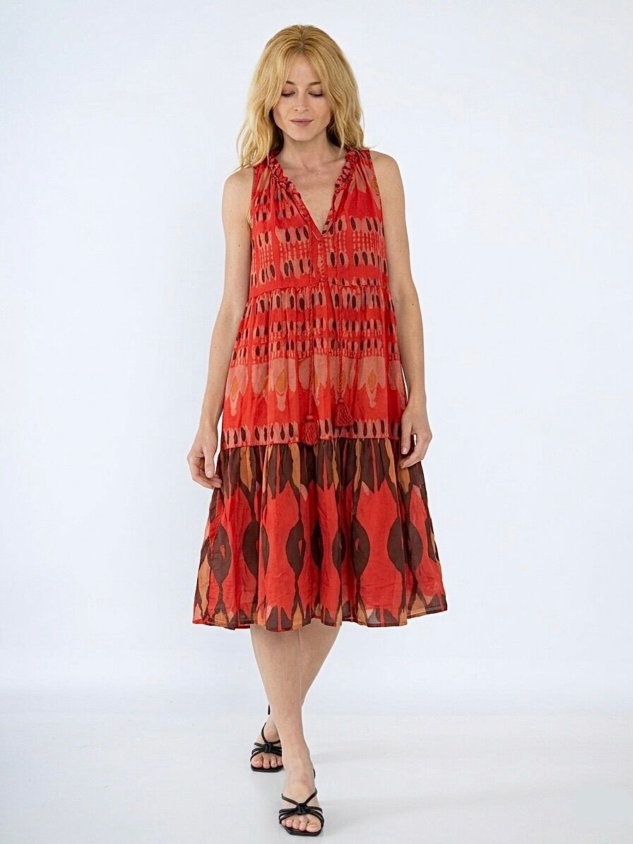Flowing dress with a delicately ruffled V-neckline, extended by two braided tie cords finished with tassels, large ruffle at the hem, geometric IKAT-inspired pattern