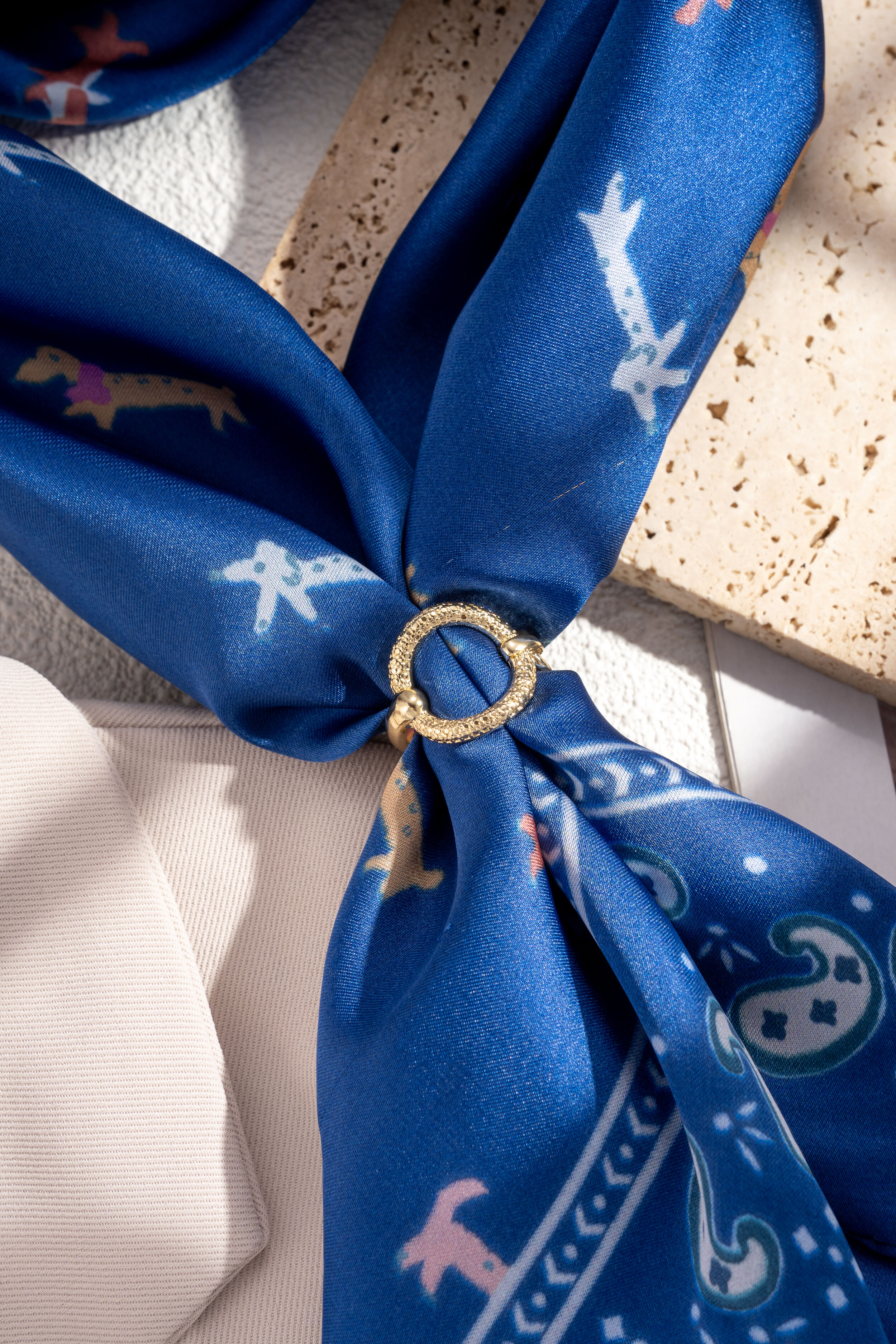 Round rhodium-plated metal scarf buckle with a chic, shiny texture