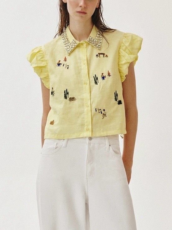 Short, sleeveless shirt with ruffles, embroidery, and a decorated collar