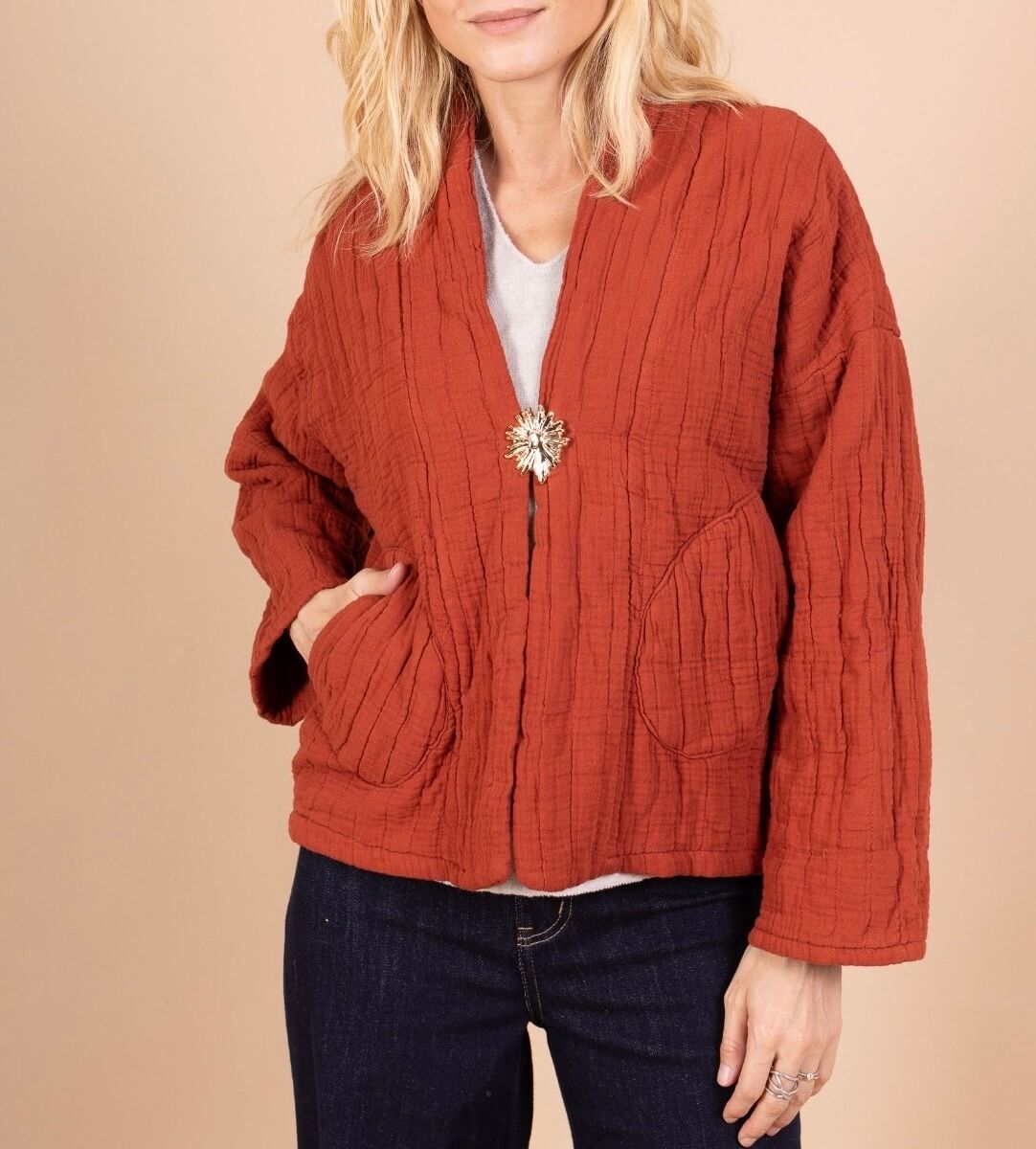 Veste matelassée en gaze de coton esprit kimono manches longues surpiqûres verticales 2 poches plaquées arrondies à l'avant broche amovible dorée soleil