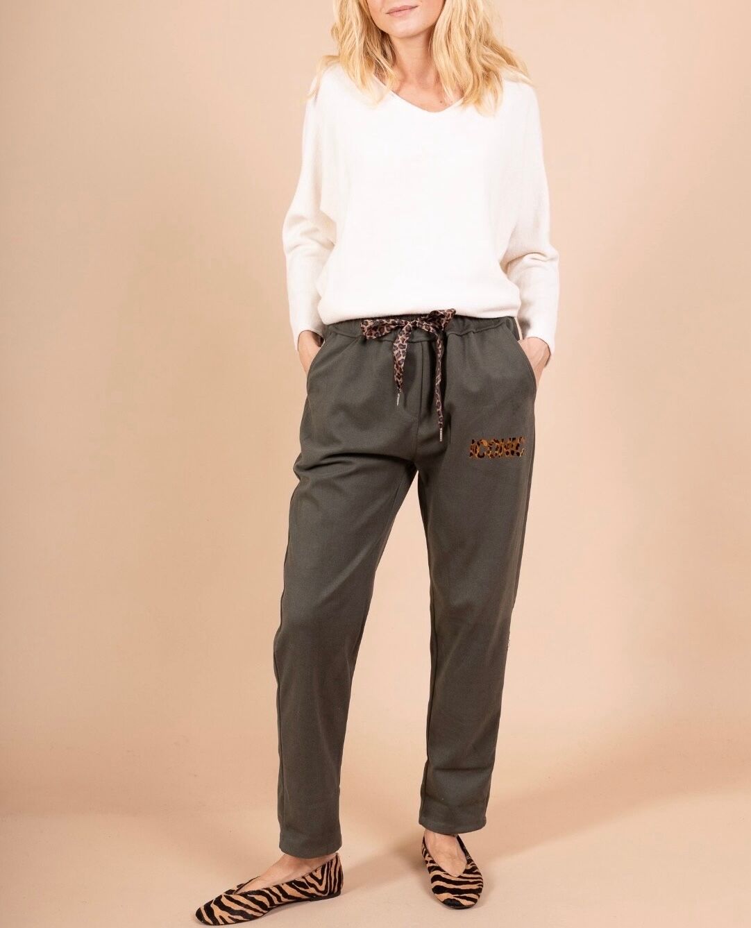 Pantalon 7/8 coupe carotte taille élastiquée froncée avec lien de serrage imprimé léopard 2 poches latérales et arrière inscription "ICONIC" en léopard scintillant