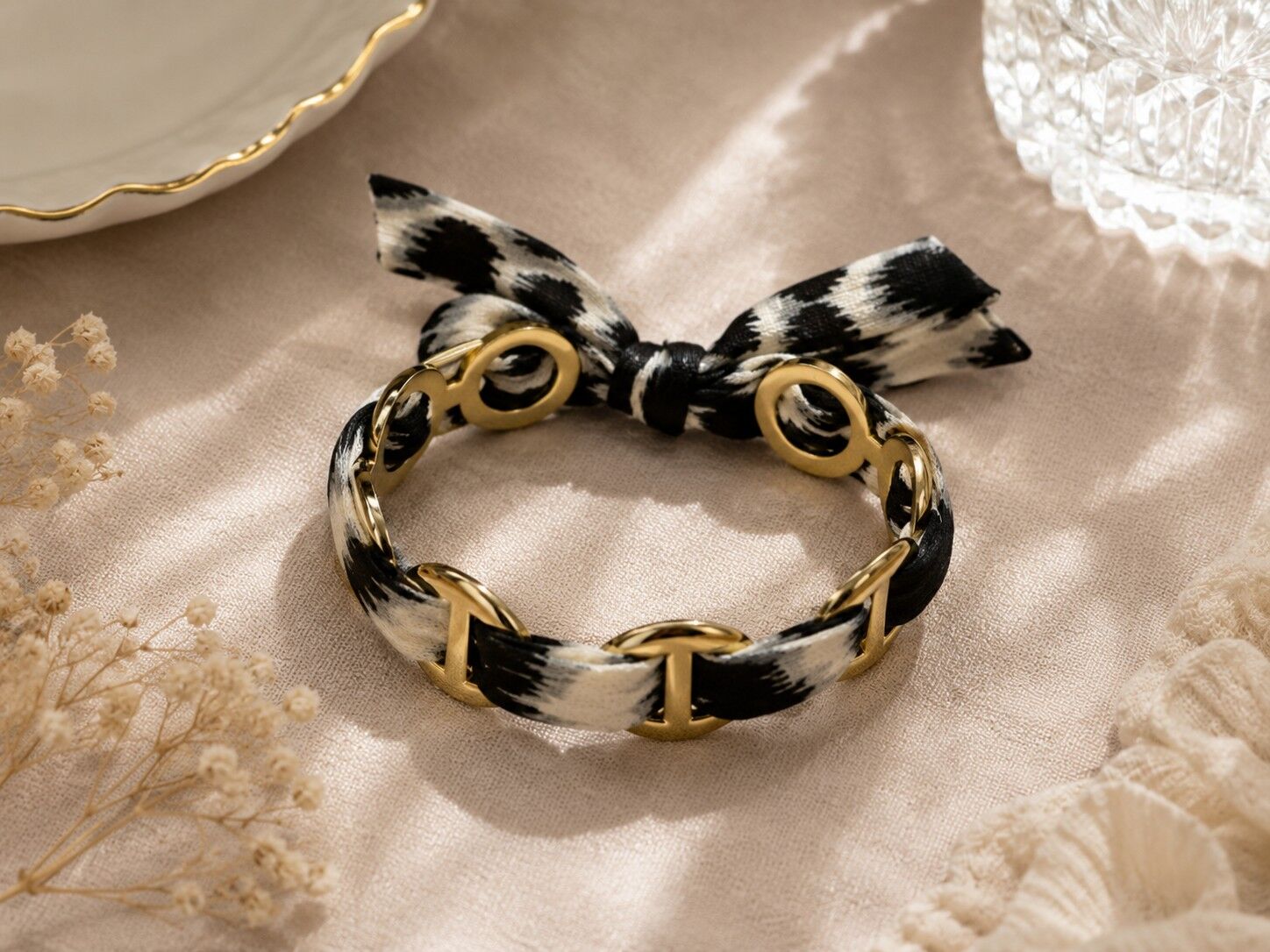 Modernes ovales Gliederarmband aus goldfarbenem, geflochtenem, schwarz-weiß bedrucktem Stoff