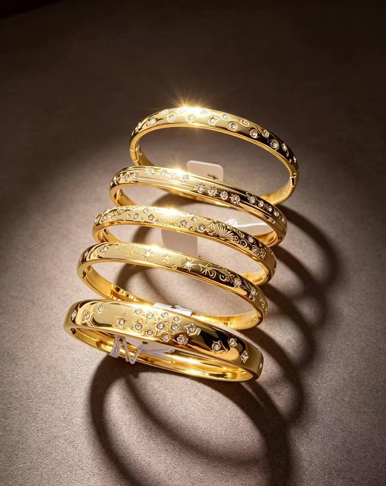 Set aus 5 breiten, stapelbaren, schimmernden Goldarmreifen im Bohemian-Chic-Stil.