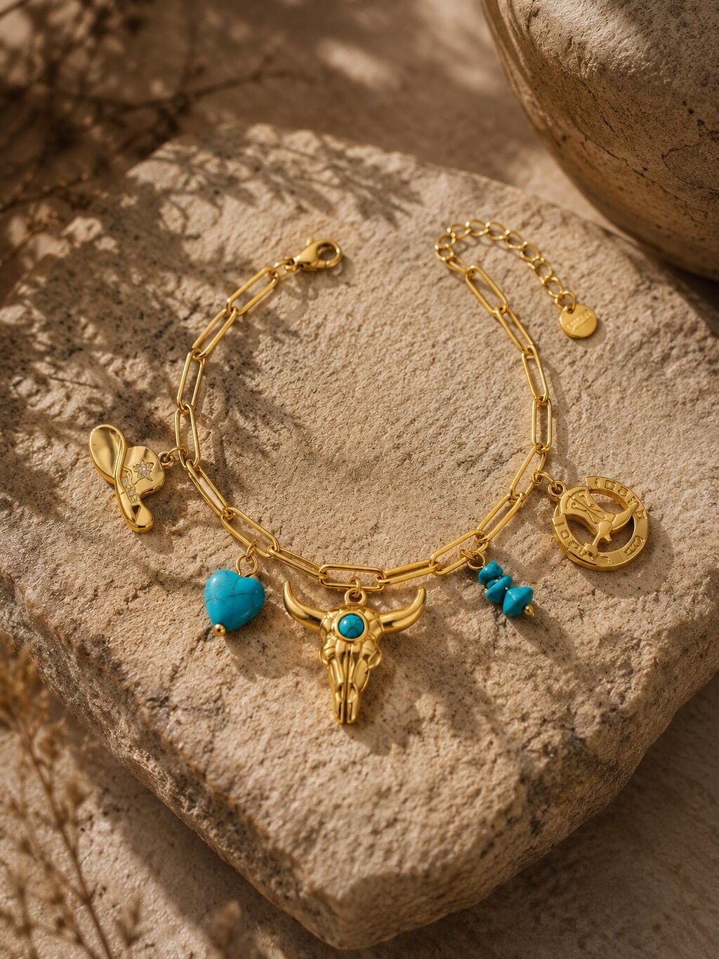 Goldfarbenes Armband mit türkisfarbenen Western-Anhängern, Stier-, Herz- und Hutmotiv aus Edelstahl.