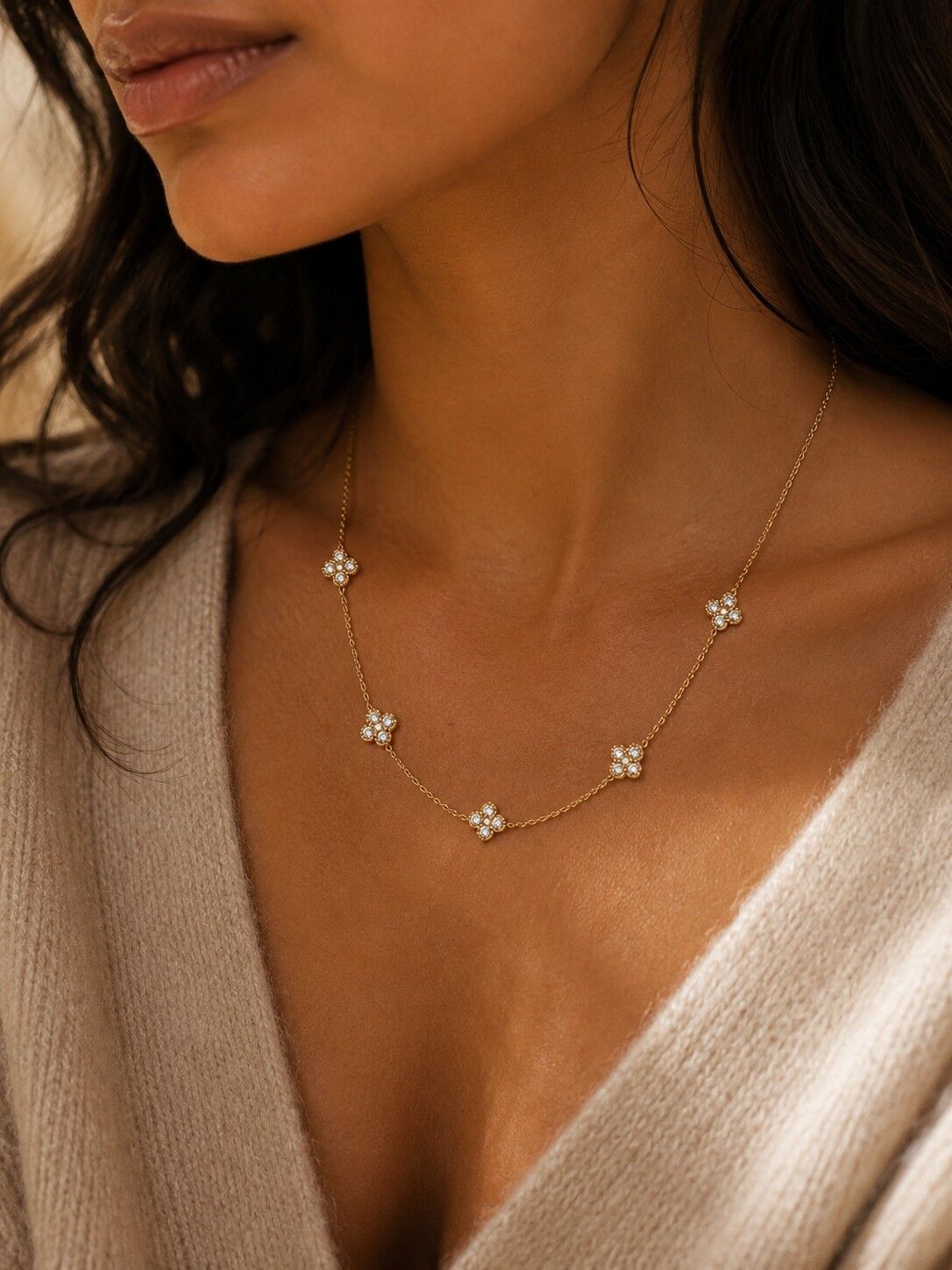 Feine Goldkette mit Kleeblättern und zarten weißen Steinen, leuchtendes modernes Design