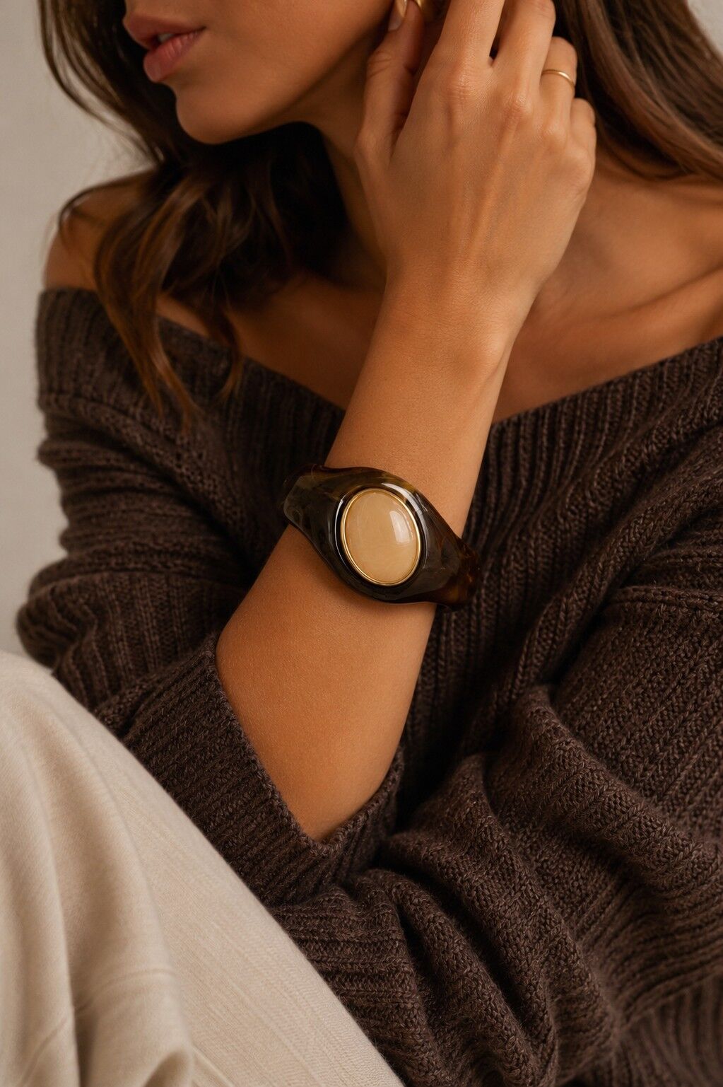 Auffälliges und elegantes Armband aus Kunstharz mit einem breiten, ovalen Mittelband, das von Gold umrandet ist.