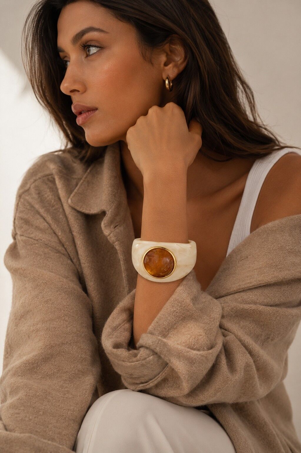 Auffälliges und elegantes Armband aus Kunstharz mit einem großen ovalen Cabochon in der Mitte, eingefasst in eine goldumrandete Fassung.