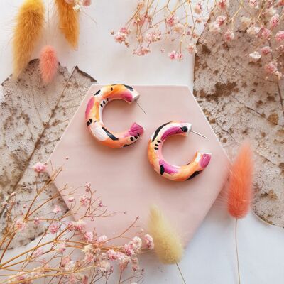 Aretes de arcilla de aro regulares con pinceladas de color naranja, rosa y negro