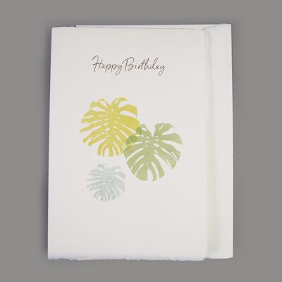 Tarjeta de papel hecha a mano "Feliz cumpleaños" con hojas de filodendro