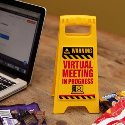 Warnschild „Virtuelle Besprechung“ am Schreibtisch